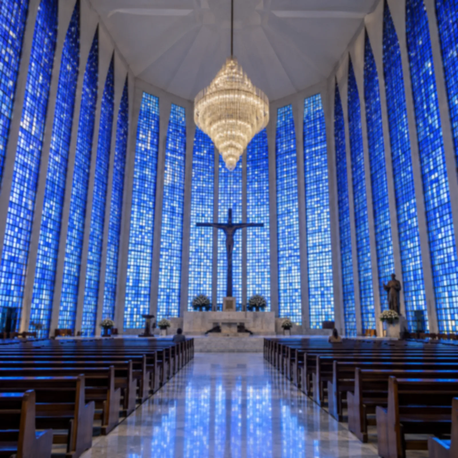 Nave de igreja inteiramente revestida por vitrais azuis em tons variados.