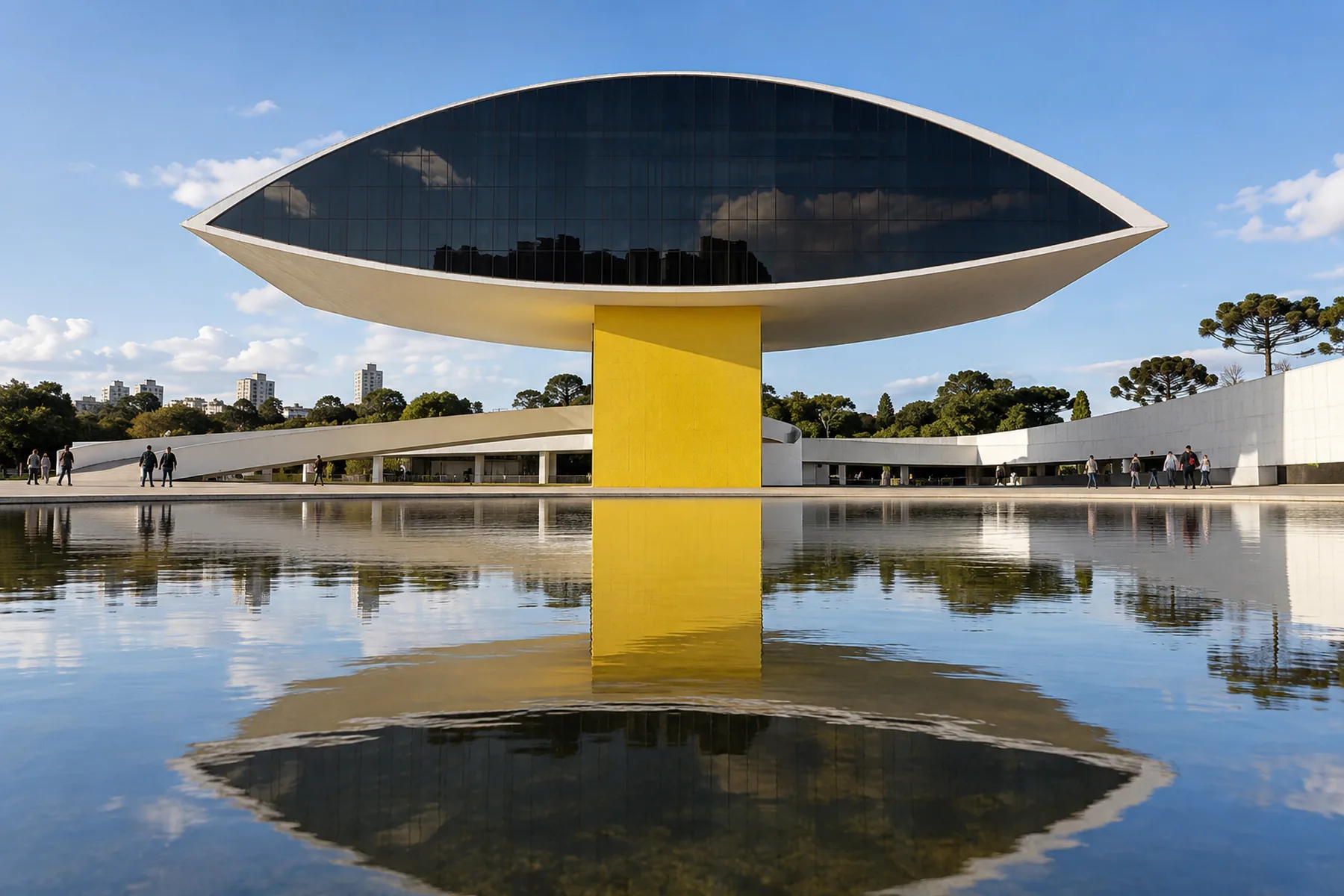Edifício em forma de olho amarelo e branco suspenso sobre pilar.