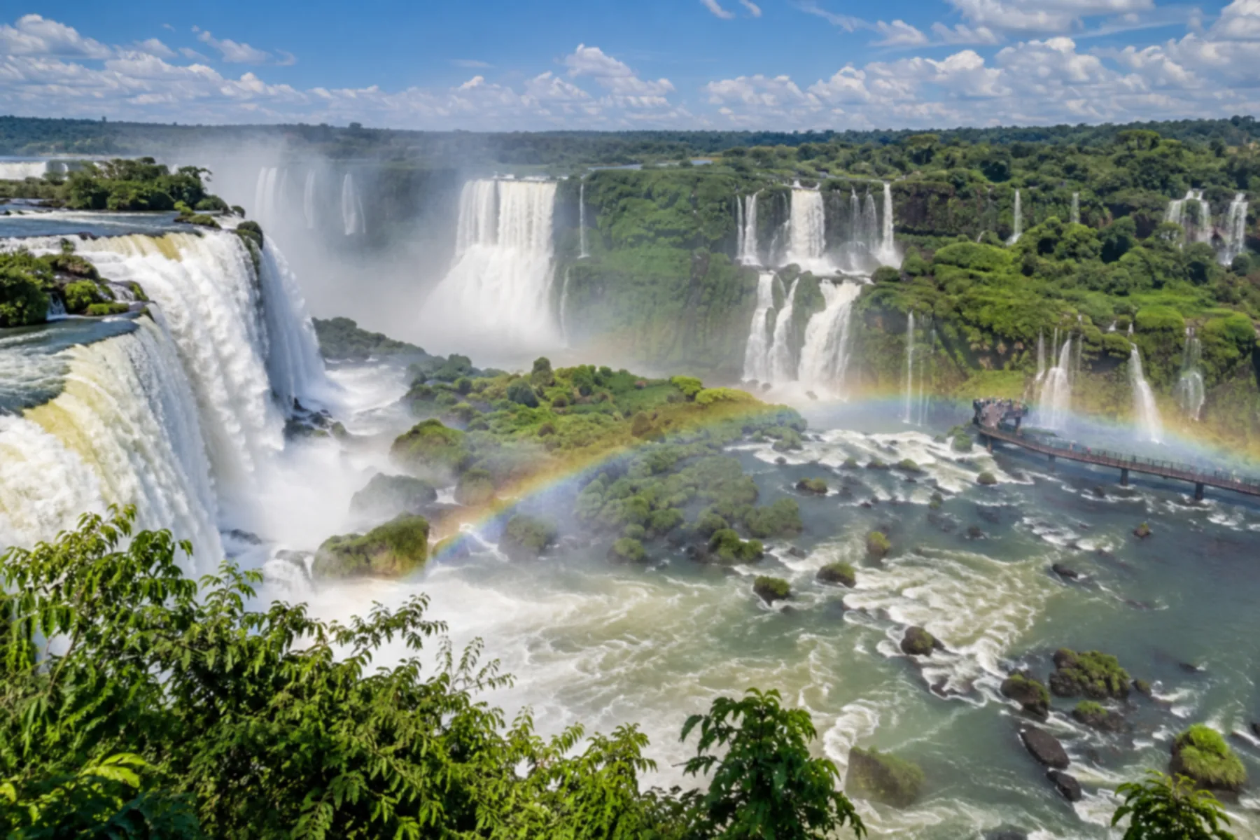 Vista panorâmica de dezenas de quedas d'água em semicírculo dentro da mata.