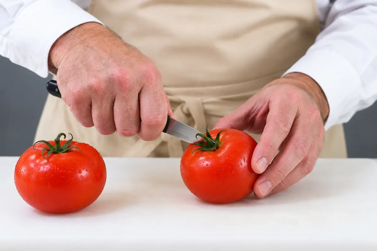 Preparo dos tomates crus para a salade niçoise.